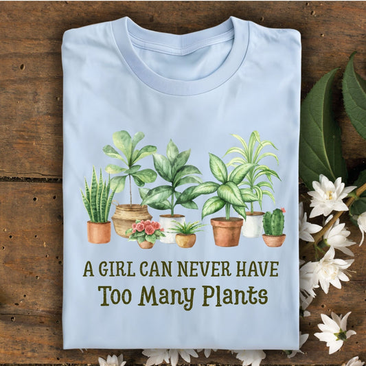 Light blue S t-shirt with "A Girl Can Never Have Too Many Plants" text and watercolor houseplant art.