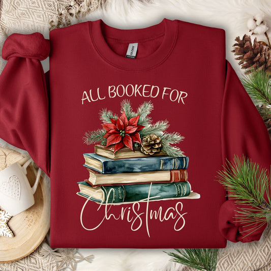 Cardinal Red sweatshirt with "All Booked for Christmas" text and a vintage watercolor stack of holiday books.