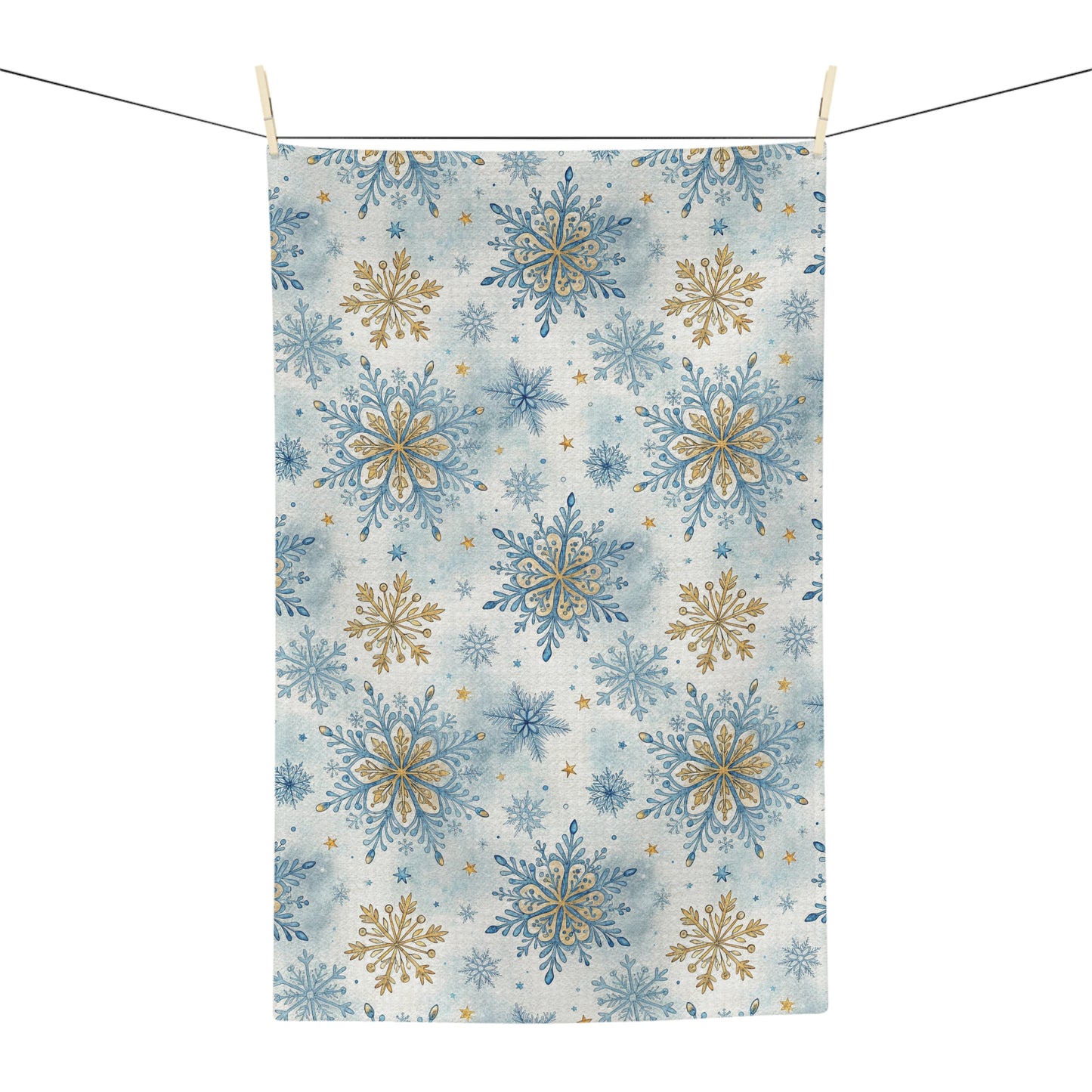 Microfiber tea towel with blue and gold snowflake pattern, hanging from a clothesline.