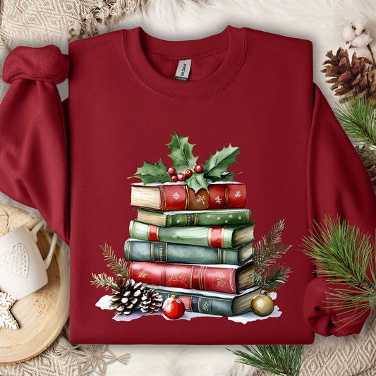 Cardinal Red Gildan sweatshirt with a watercolor stack of Christmas books, holly, pinecones, and ornaments.