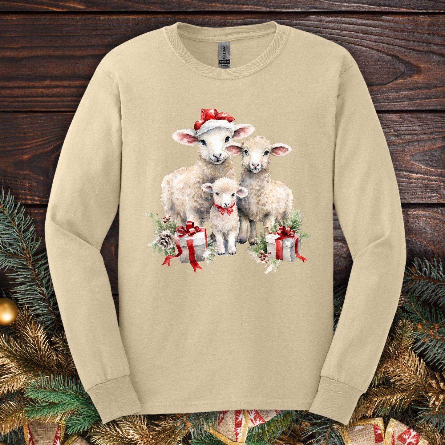 Sand Gildan long sleeve tee with watercolor Christmas lambs in Santa hats and gifts.