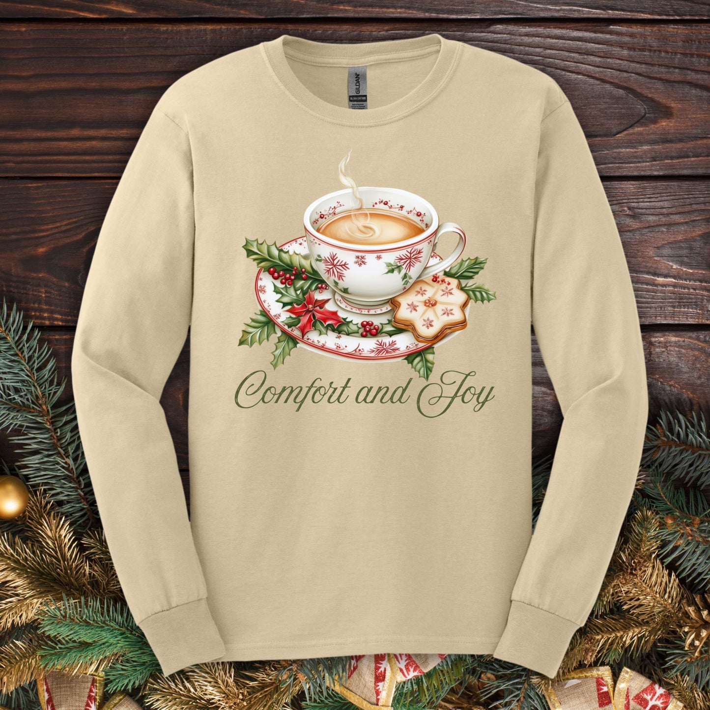 Sand long sleeve tee with watercolor teacup, evergreens, gingerbread cookie, and "Comfort and Joy" text.
