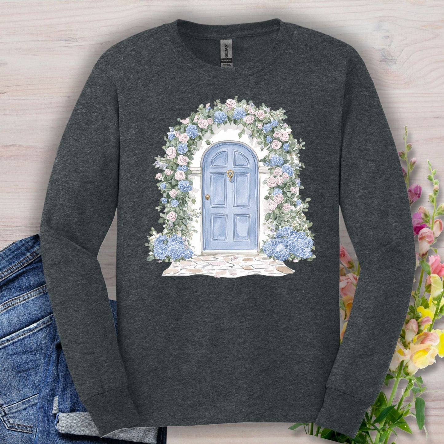 Charcoal long-sleeve tee with a watercolor blue door and pink and blue floral arch design.