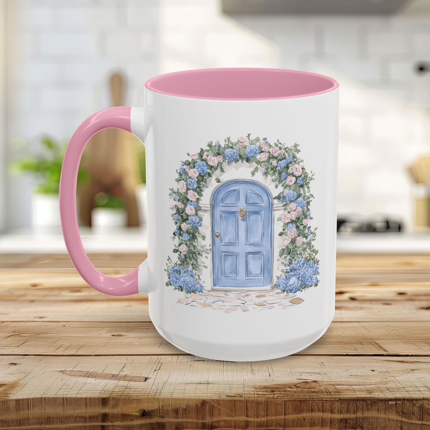 White ceramic mug with pink handle and interior, featuring a blue cottage door framed by pink and blue hydrangeas.