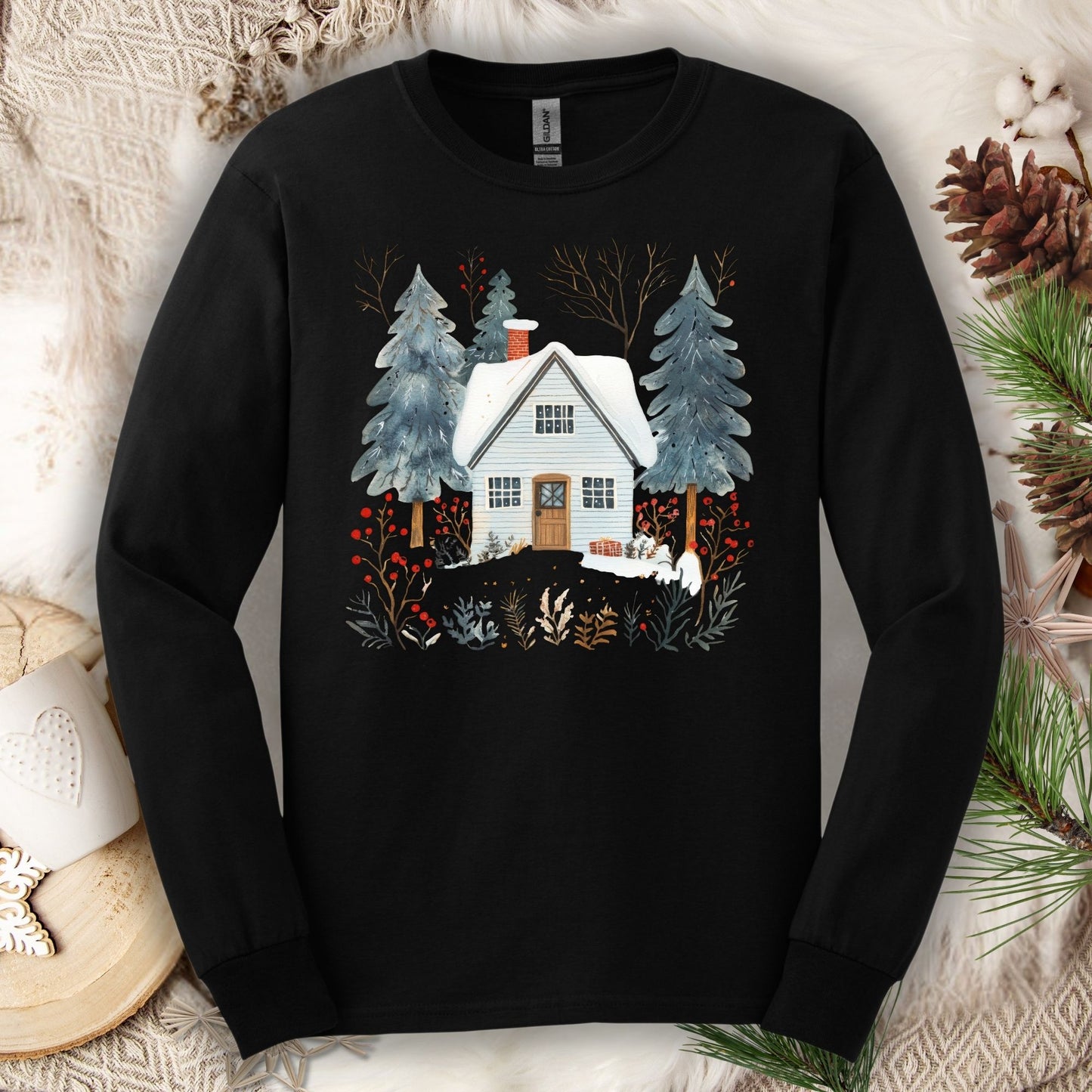 Black long-sleeve tee with a hand-drawn Nordic winter cabin and pine trees design.