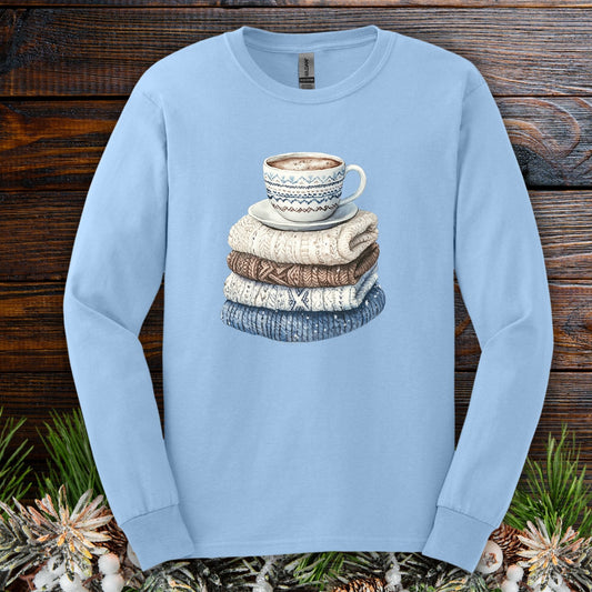 Light blue long-sleeve cotton tee with a cozy illustration of a steaming coffee mug on knit sweaters.