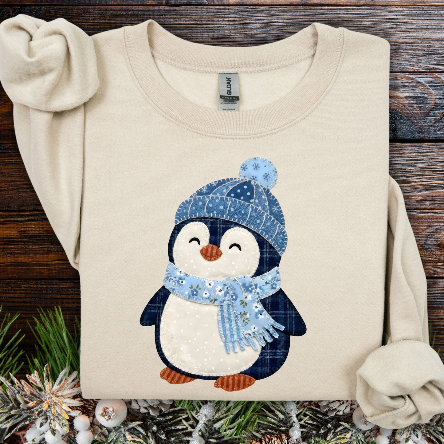 Sand S sweatshirt with faux patchwork penguin in blue hat and scarf.