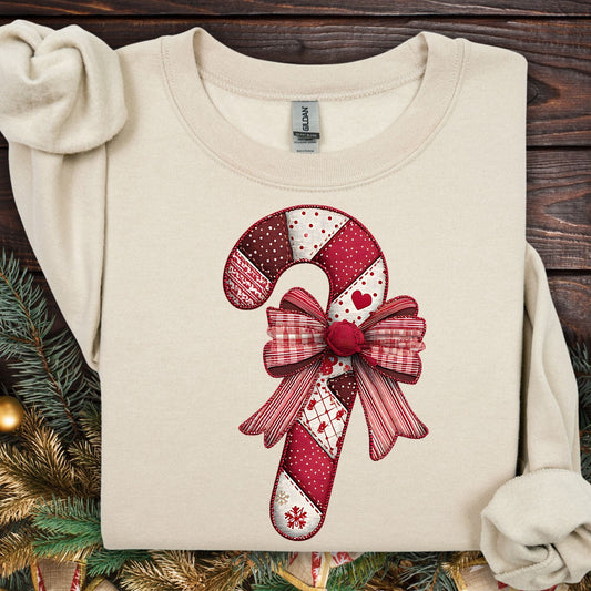 Sand Gildan sweatshirt with a vintage faux patchwork candy cane and red bow design.