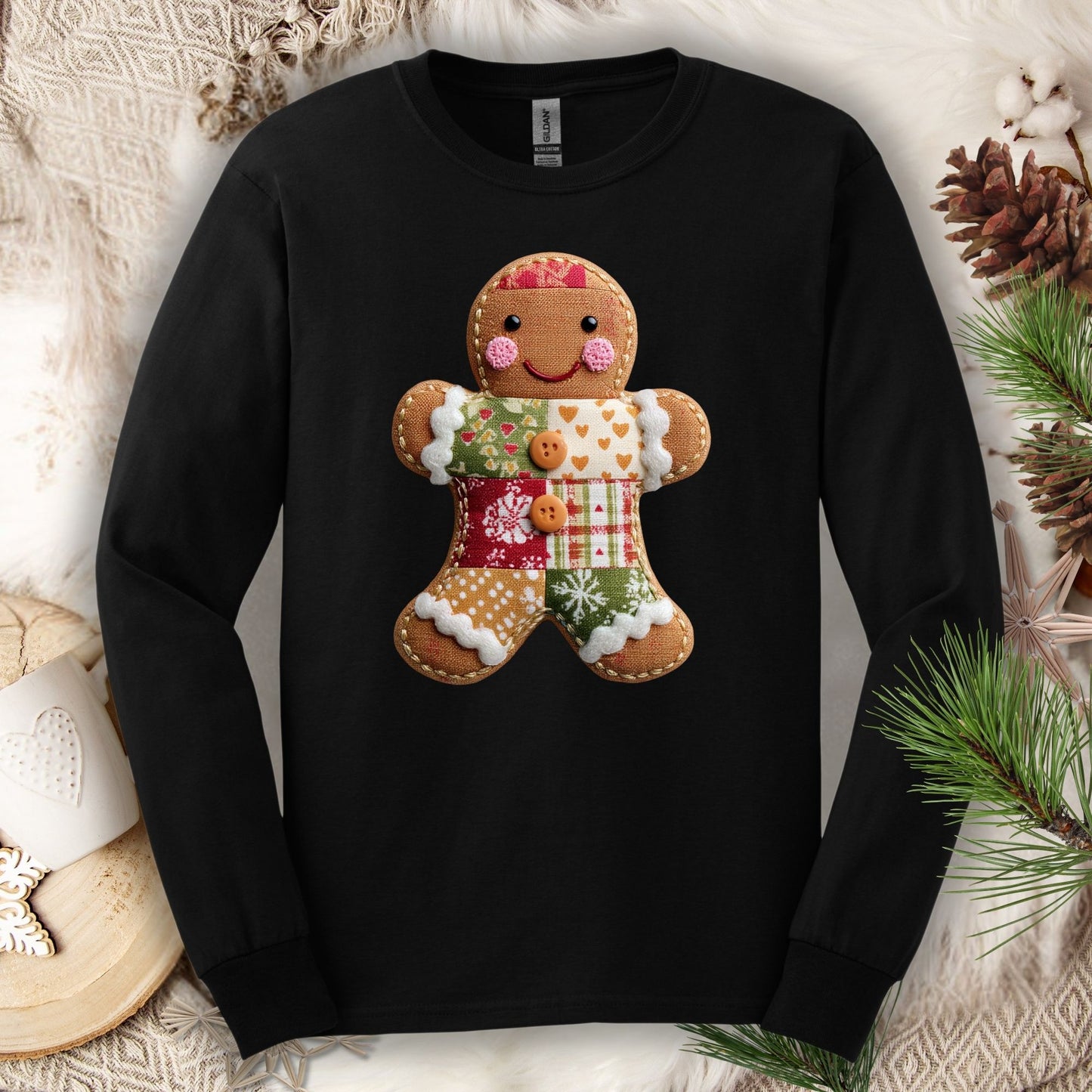 Black Gildan long sleeve tee with a faux patchwork gingerbread man design, surrounded by cozy holiday decor.