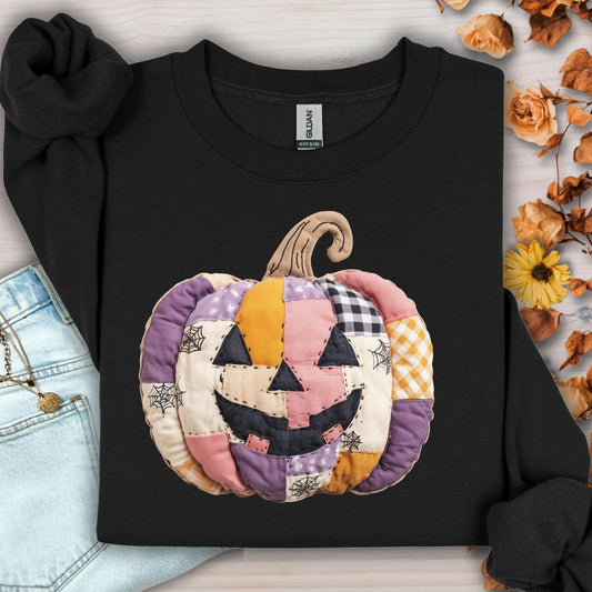 Black Gildan sweatshirt with a pink and purple patchwork jack-o-lantern design.