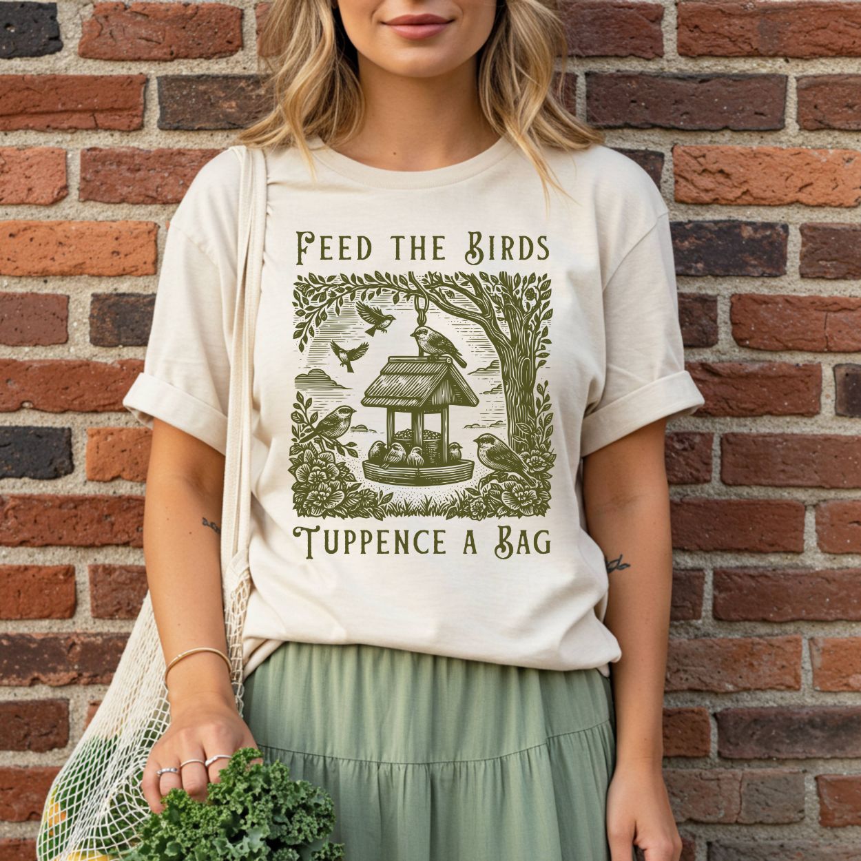 Unisex cream tee with vintage green "Feed the Birds Tuppence a Bag" graphic featuring a bird feeder and tree.