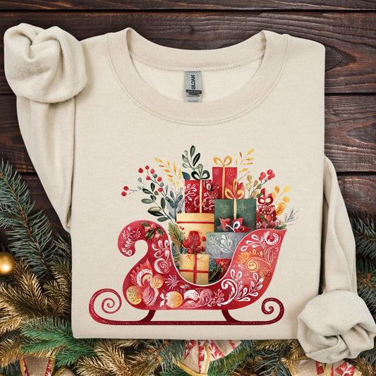 Sand Gildan crewneck sweatshirt with a folk art Christmas sleigh brimming with gifts.
