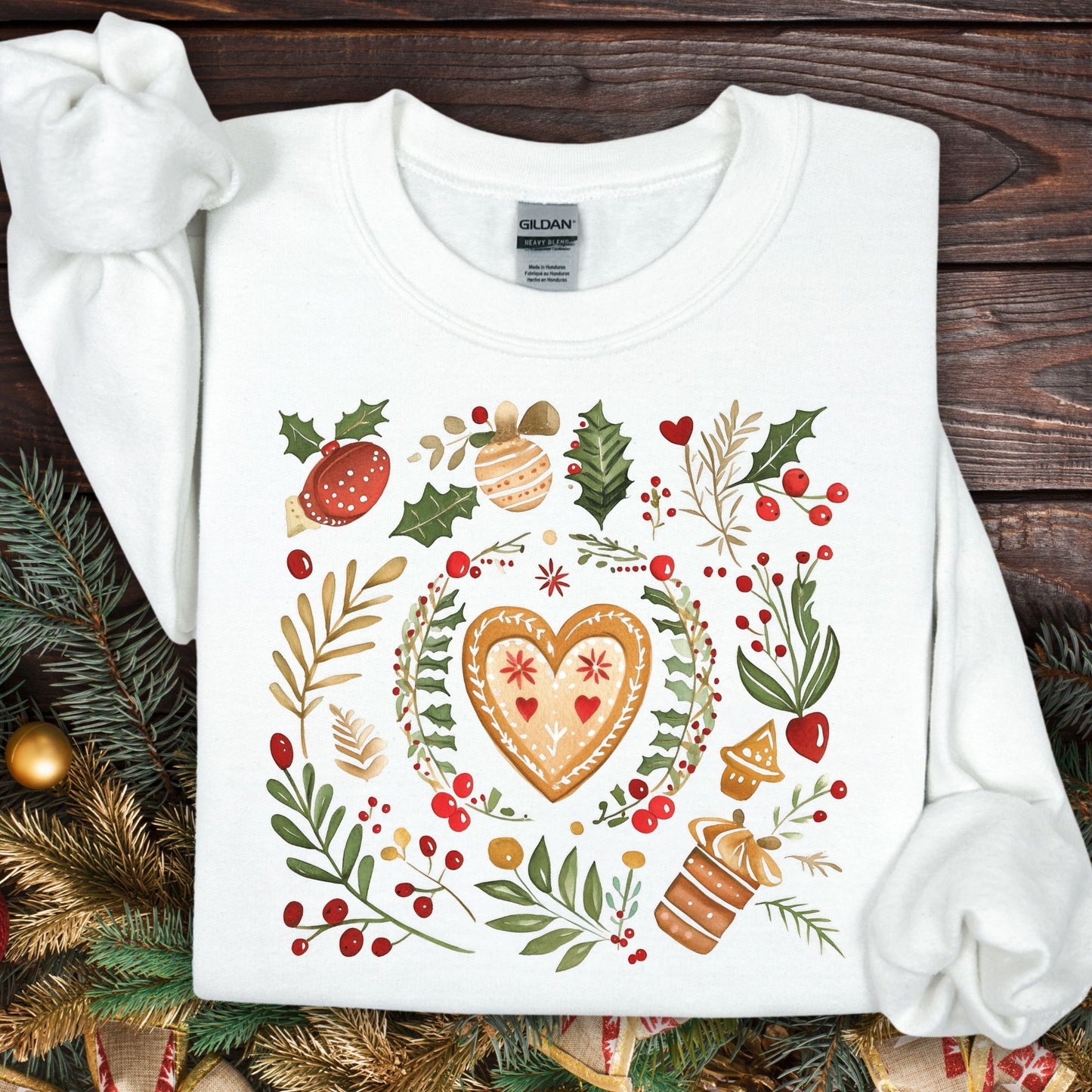 White S sweatshirt with folk art gingerbread heart, holly, and red berry design.