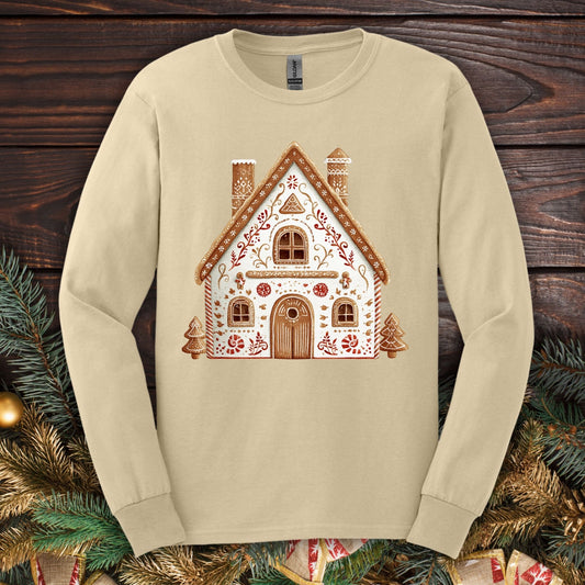 Sand Gildan long sleeve tee with a folk art gingerbread house design in watercolor tones.