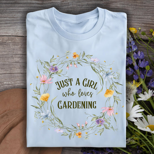 Light blue S t-shirt with "Just a Girl who loves Gardening" text in a wildflower wreath design.