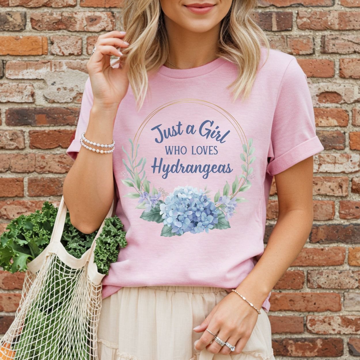 Pink garment-dyed cotton t-shirt with "Just a Girl Who Loves Hydrangeas" text and blue watercolor hydrangeas.