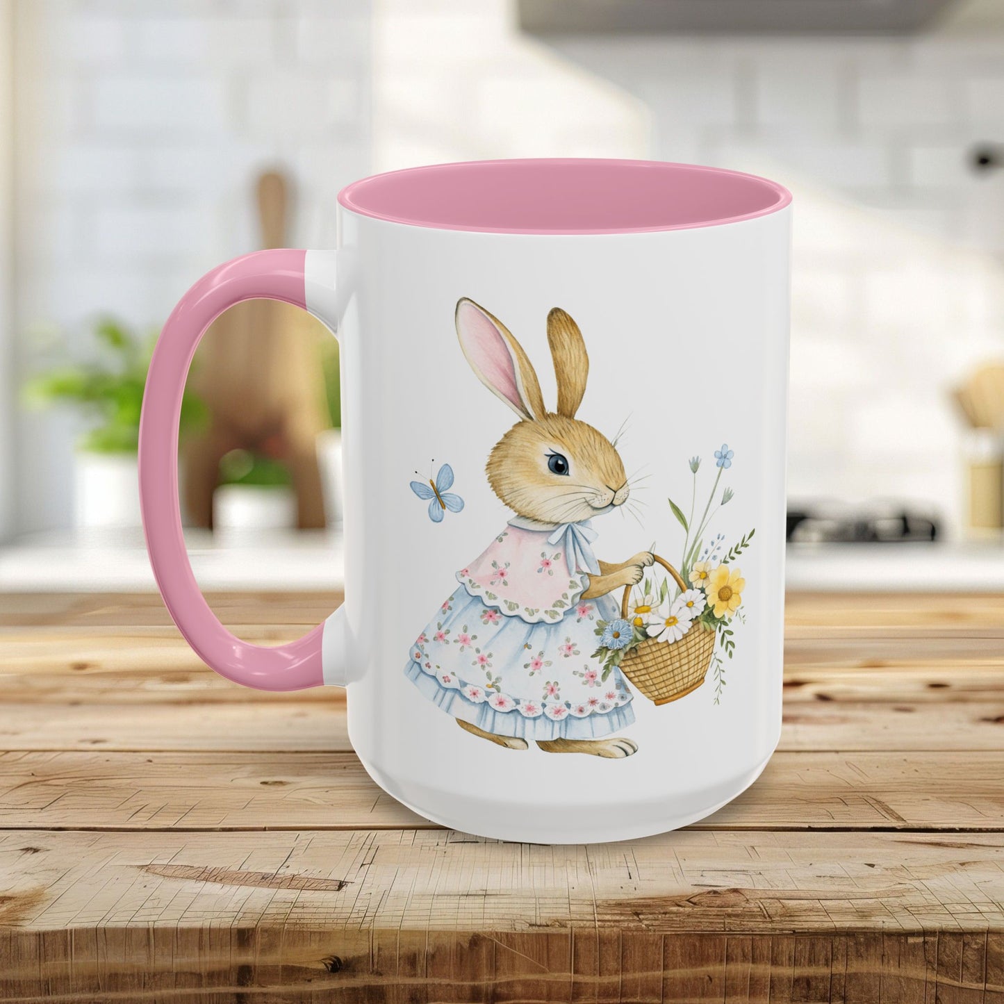 White ceramic mug with pink handle and interior, featuring a watercolor bunny in a dress holding a flower basket.