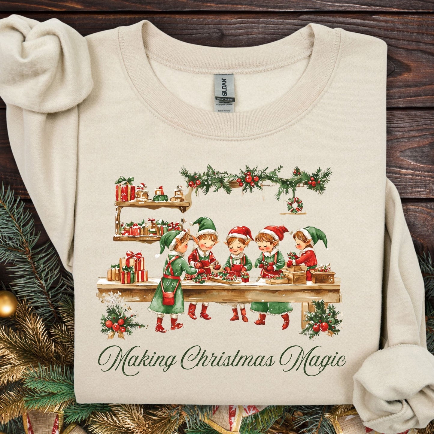 Sand S sweatshirt with vintage elves in a workshop, "Making Christmas Magic" text, and festive greenery.