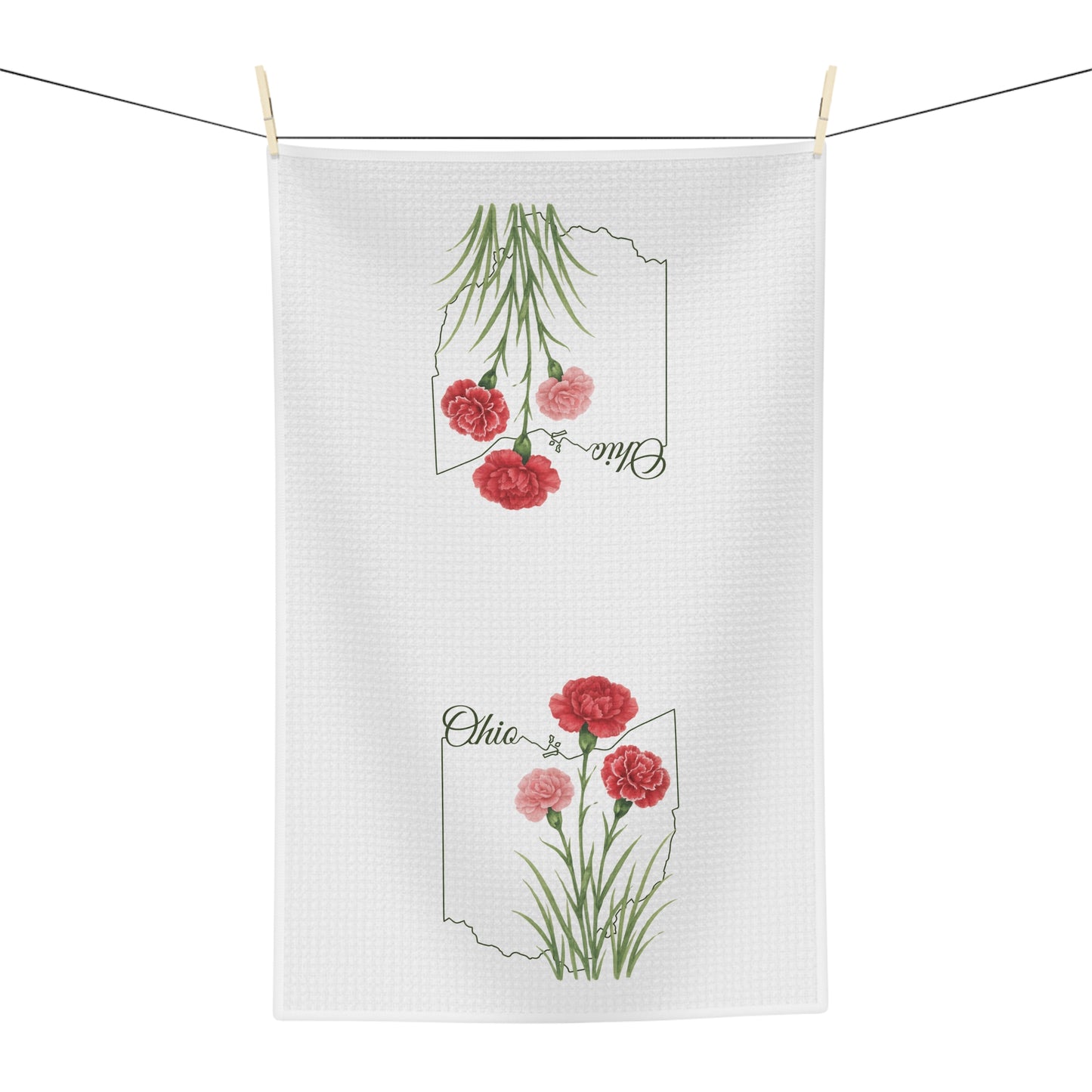 White microfiber tea towel with red and pink carnations over an Ohio outline, hanging on a line.