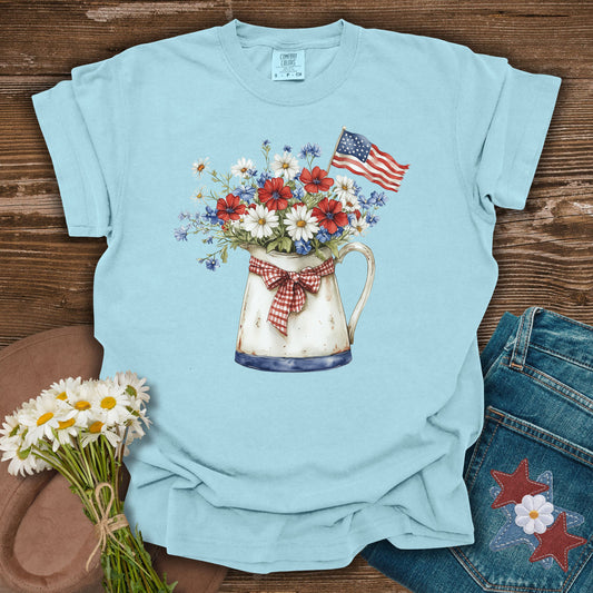 Light blue t-shirt with floral design and American flag on a wooden surface