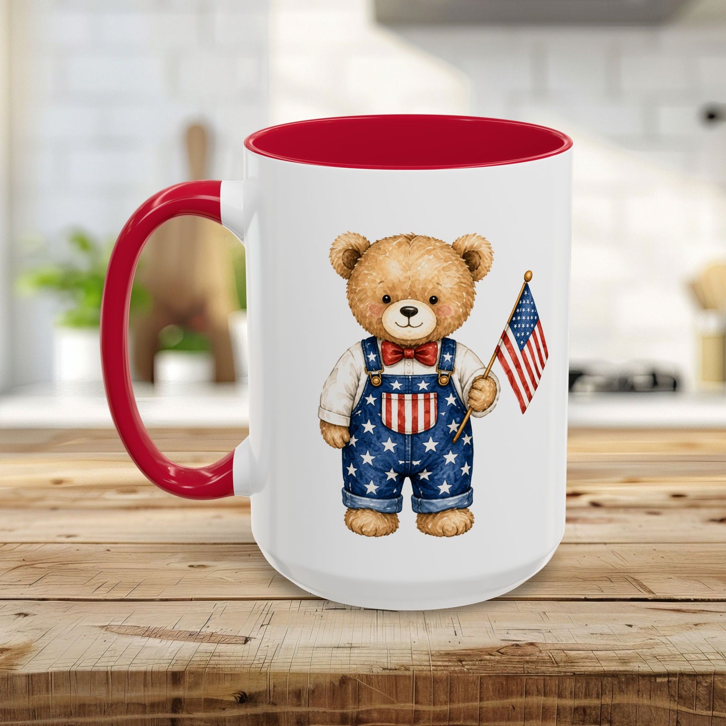 White ceramic mug with red interior and handle, featuring a watercolor teddy bear in star-spangled overalls holding a US flag.
