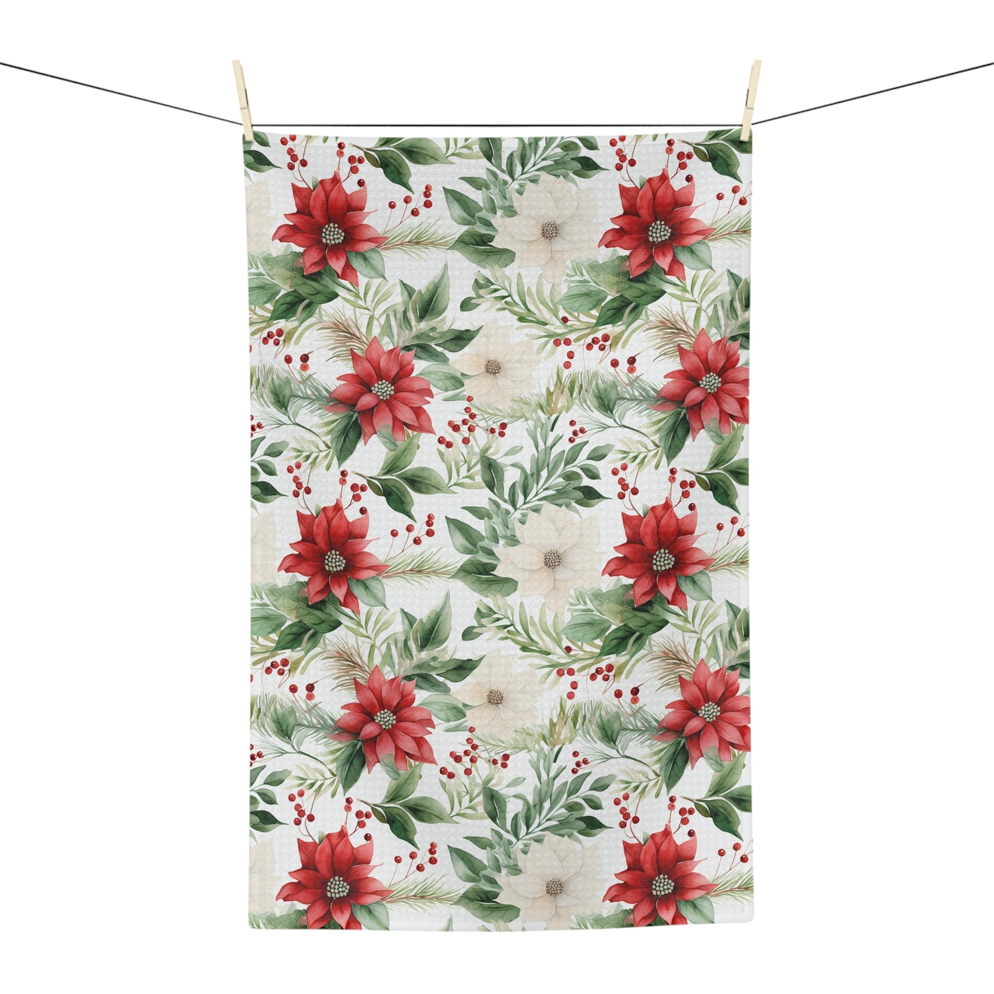 Microfiber tea towel with a vibrant watercolor poinsettia and evergreen print, hanging on a clothesline.