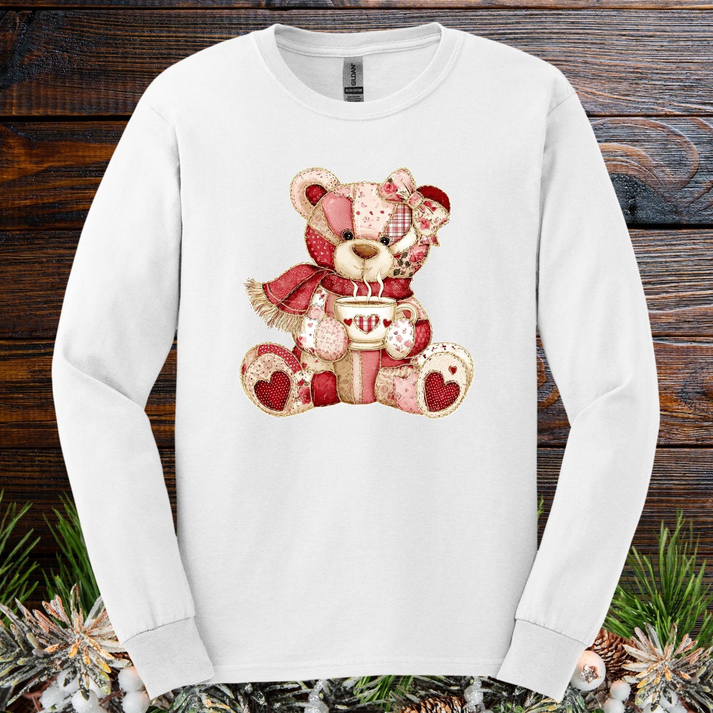 White long-sleeve tee with a red patchwork country teddy bear holding hot chocolate.