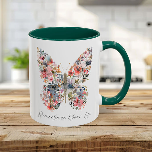 White 11oz ceramic mug with a green handle and interior, featuring a watercolor floral butterfly and "Romanticize Your Life" text.
