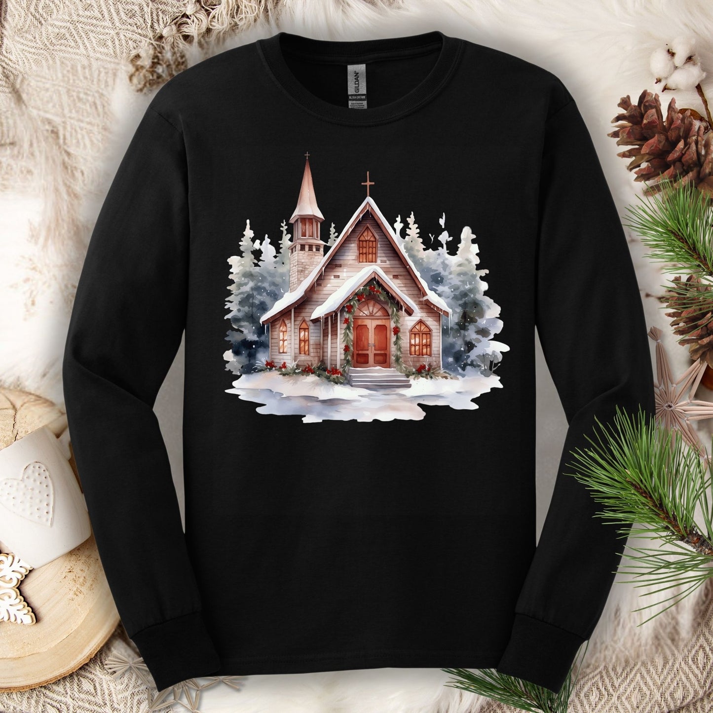 Black Gildan long sleeve tee with a rustic chapel in snow, holly, and pine garland.