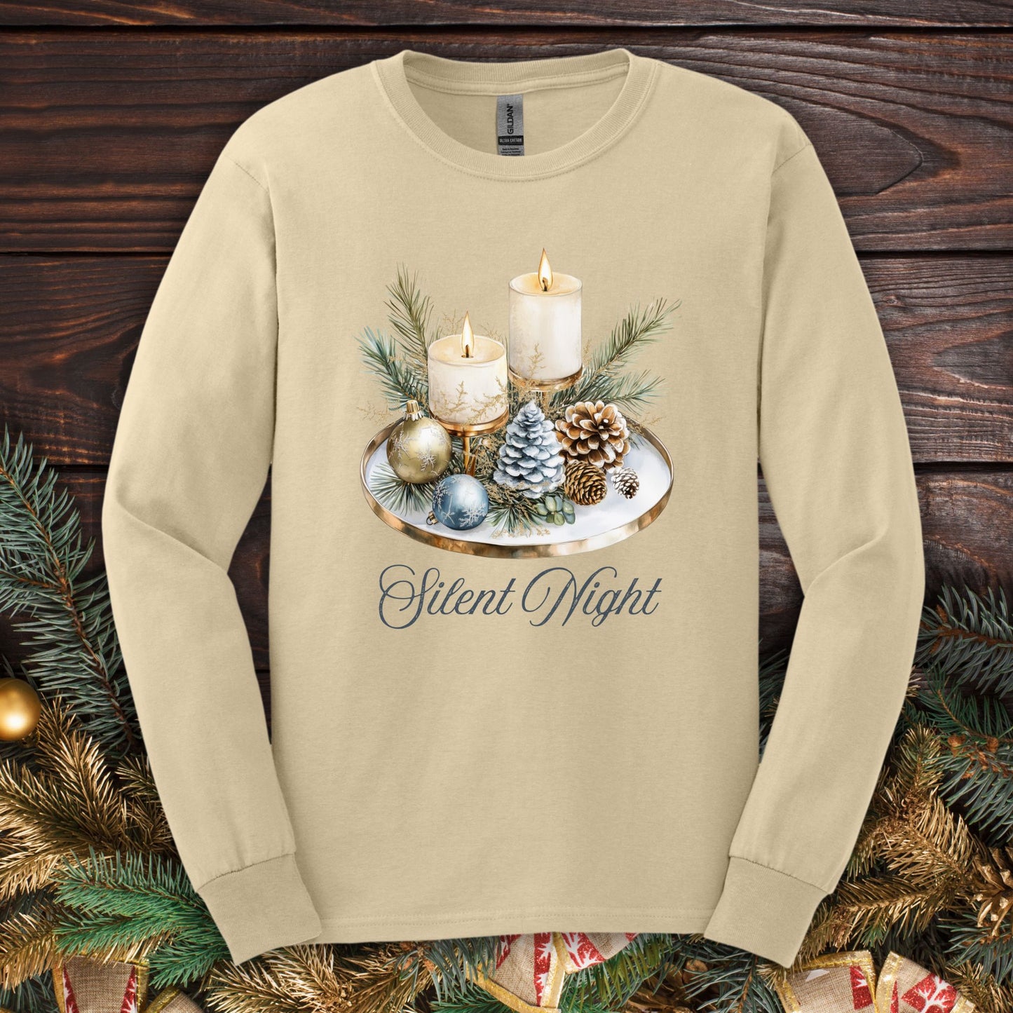 Sand long sleeve tee with a watercolor advent arrangement featuring candles, evergreens, ornaments, and "Silent Night.