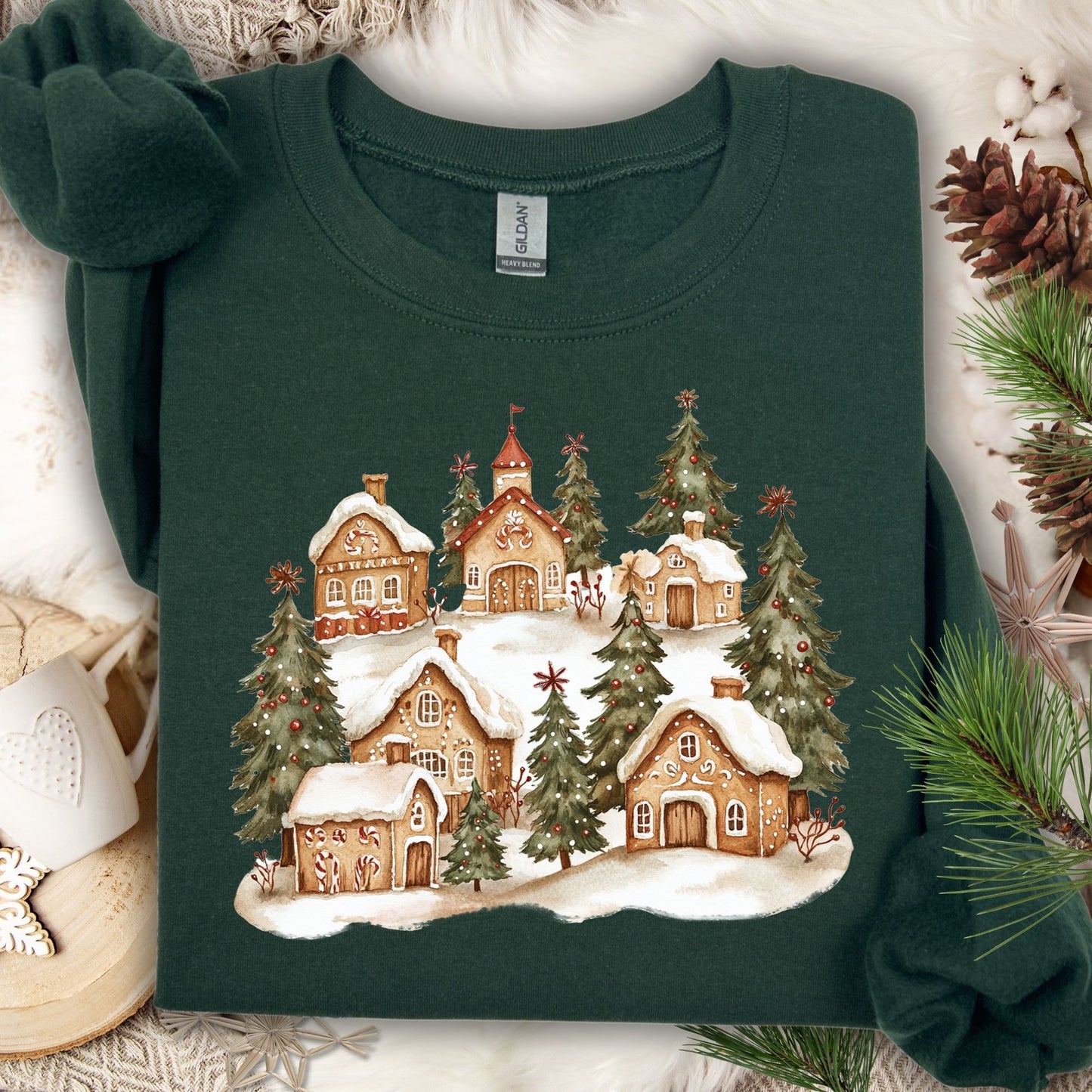 Forest Green Gildan sweatshirt with a watercolor snowy gingerbread village and evergreen trees.