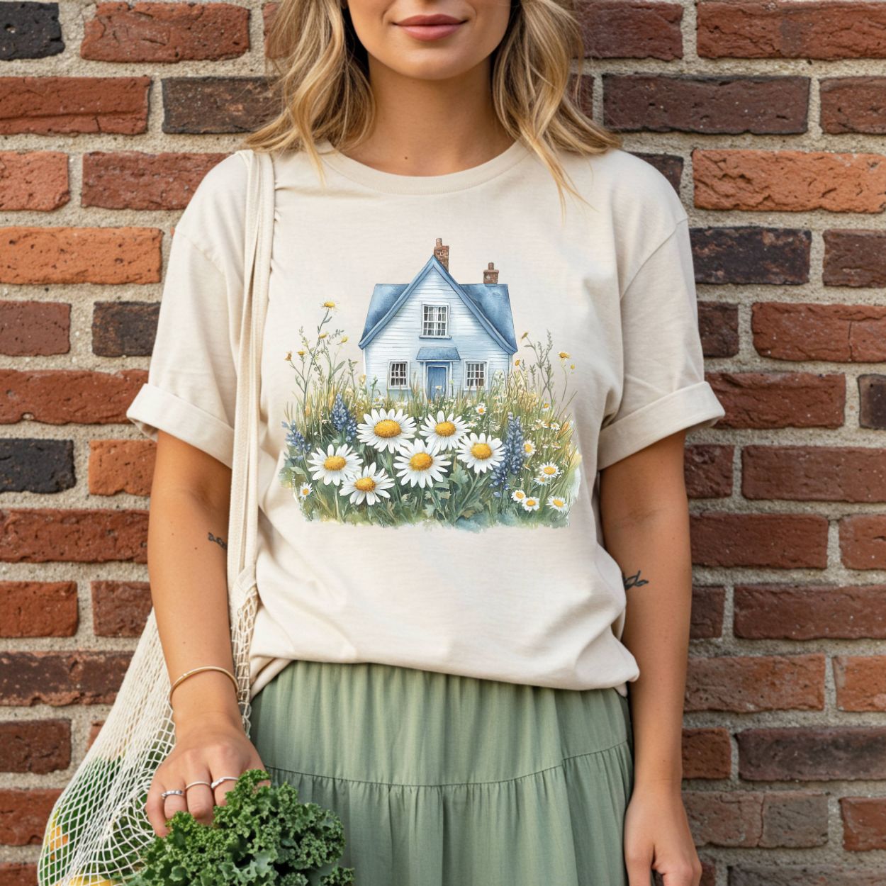 Garment-dyed, relaxed-fit t-shirt with a blue cottage and wildflower field graphic on cream cotton.