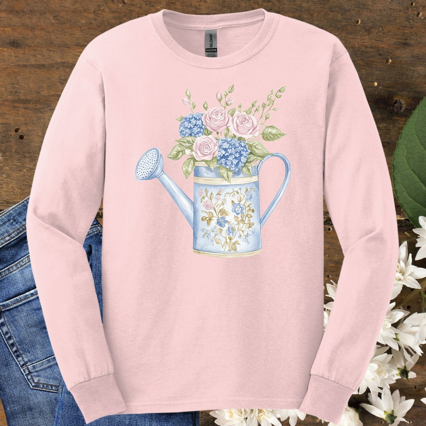 Light pink long sleeve tee with a watercolor vintage watering can and floral design.