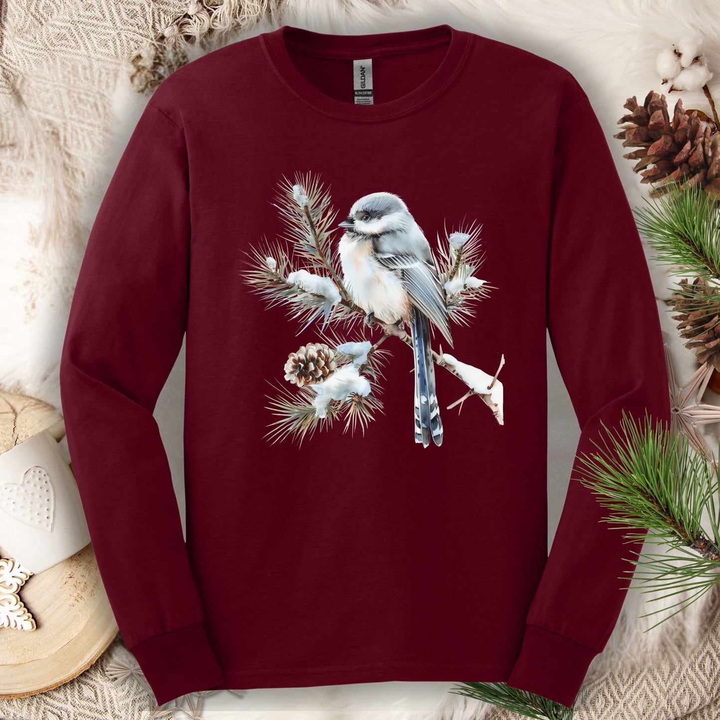 Maroon Gildan long sleeve tee with watercolor long-tailed tit on snowy evergreen branch.