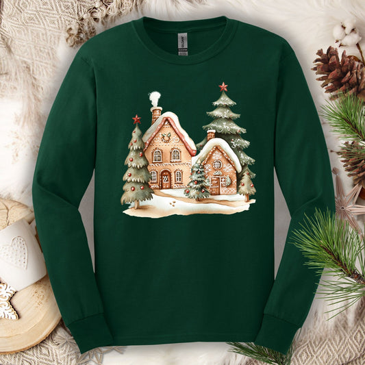 Forest Green long sleeve tee with a watercolor gingerbread house and snowy evergreen trees design.