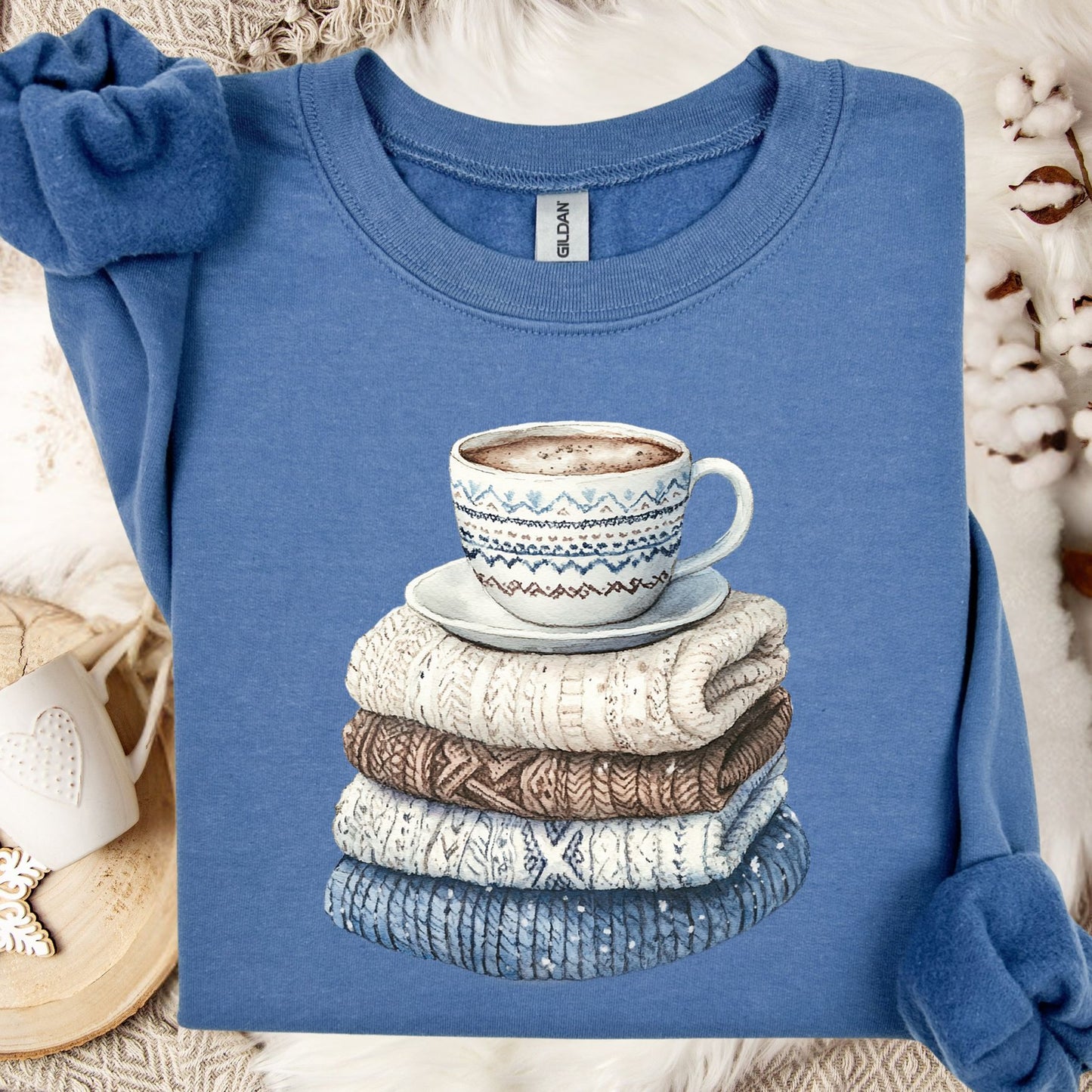 Indigo Blue Winter Wool Sweaters and Coffee Sweatshirt with a watercolor stack of knitwear and a patterned mug.