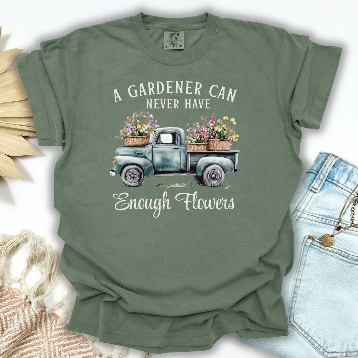 Moss green cotton t-shirt with a vintage watercolor truck spilling flowers and "A gardener can never have enough flowers" text.