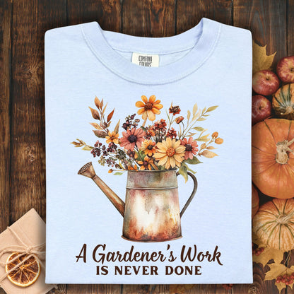 Hydrangea blue Comfort Colors t-shirt with a watering can full of fall flowers and "A Gardener's Work Is Never Done" text.