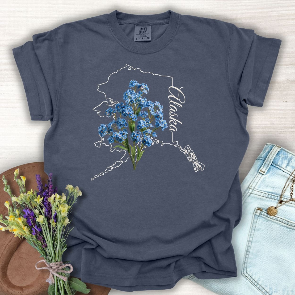 Denim S t-shirt with Alaska outline and blue forget-me-not flowers.