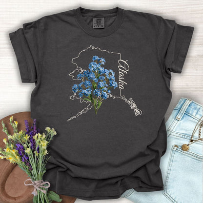 Pepper S-sized cotton t-shirt with white Alaska outline and blue forget-me-not flowers.