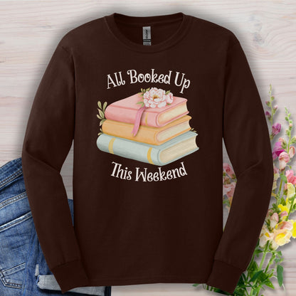 Dark Chocolate long sleeve tee with "All Booked Up This Weekend" text, pastel books, and a flower.