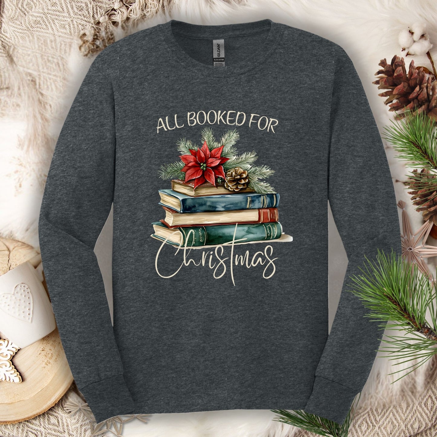 Dark Heather long sleeve tee with vintage watercolor stack of books, poinsettia, and "All Booked for Christmas" text.
