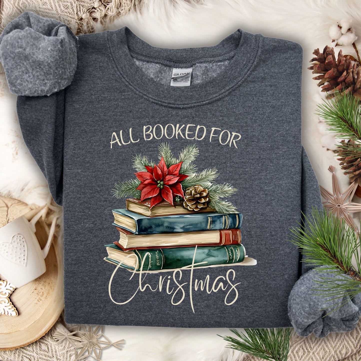 Dark Heather unisex sweatshirt with "All Booked for Christmas" text and vintage watercolor holiday book stack design.
