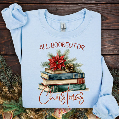 Light blue fleece sweatshirt with "All Booked for Christmas" text and vintage watercolor holiday book stack design.