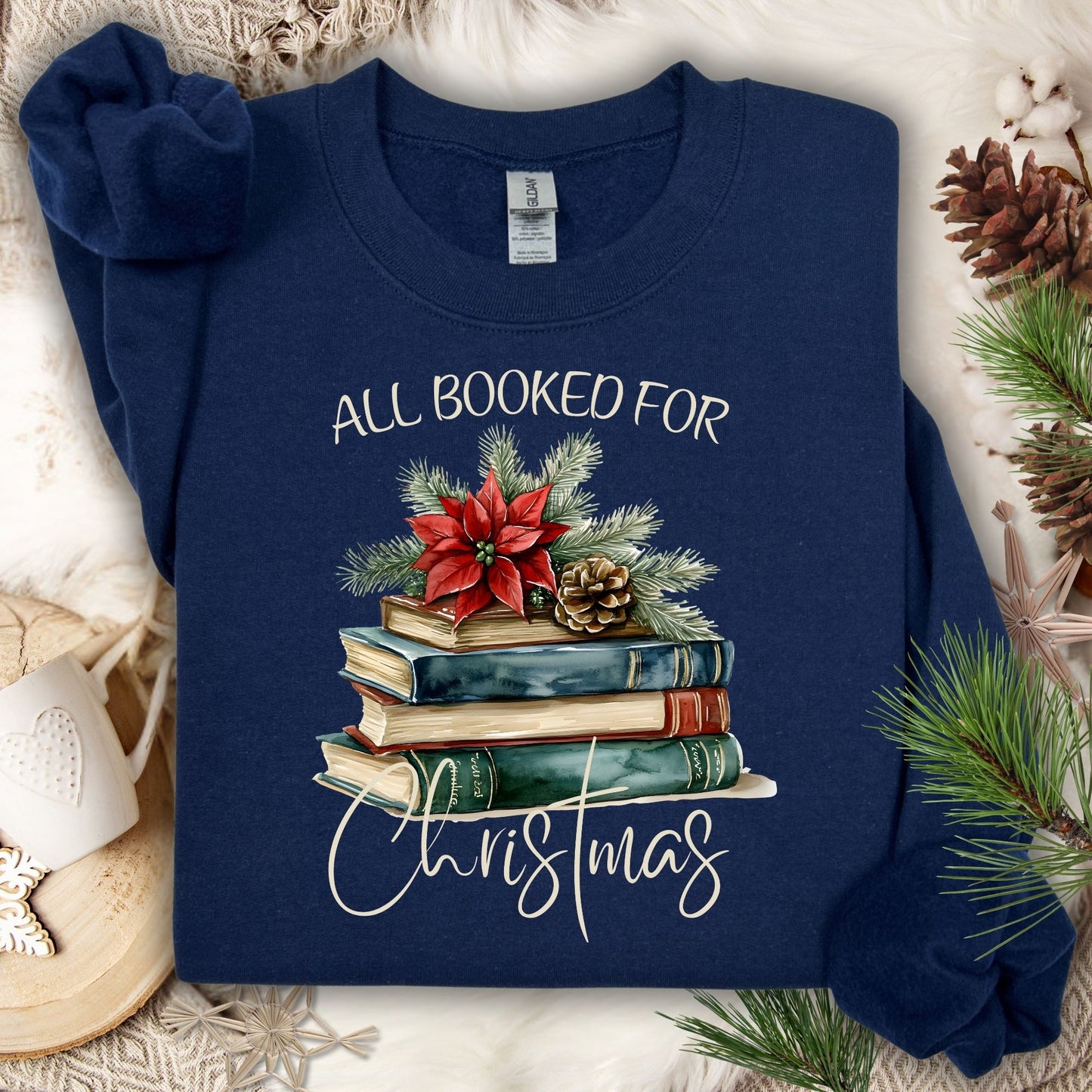 Navy "All Booked for Christmas" sweatshirt with vintage watercolor books, poinsettia, and pinecone design.