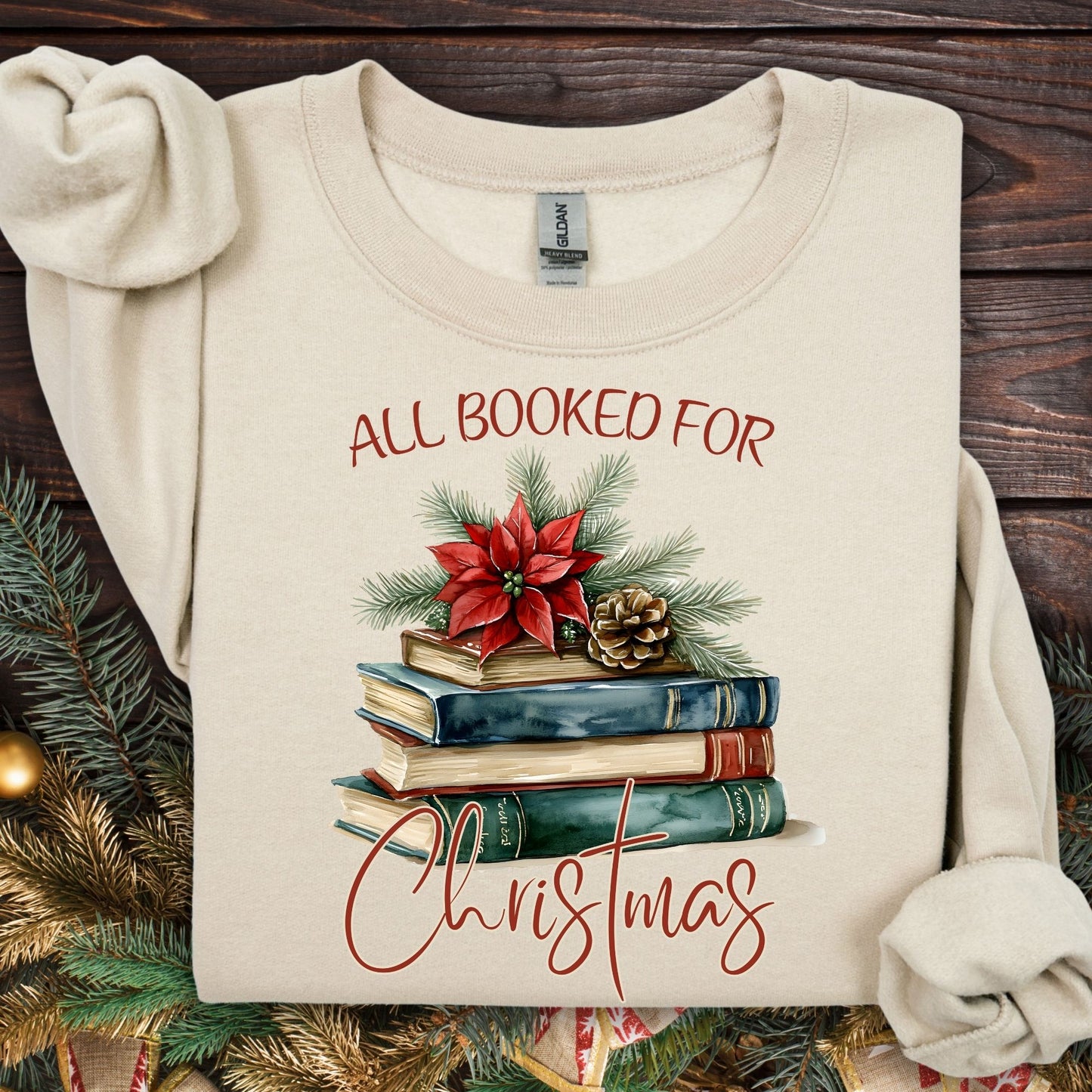 Sand "All Booked for Christmas" sweatshirt with vintage watercolor books, poinsettia, and evergreen design.