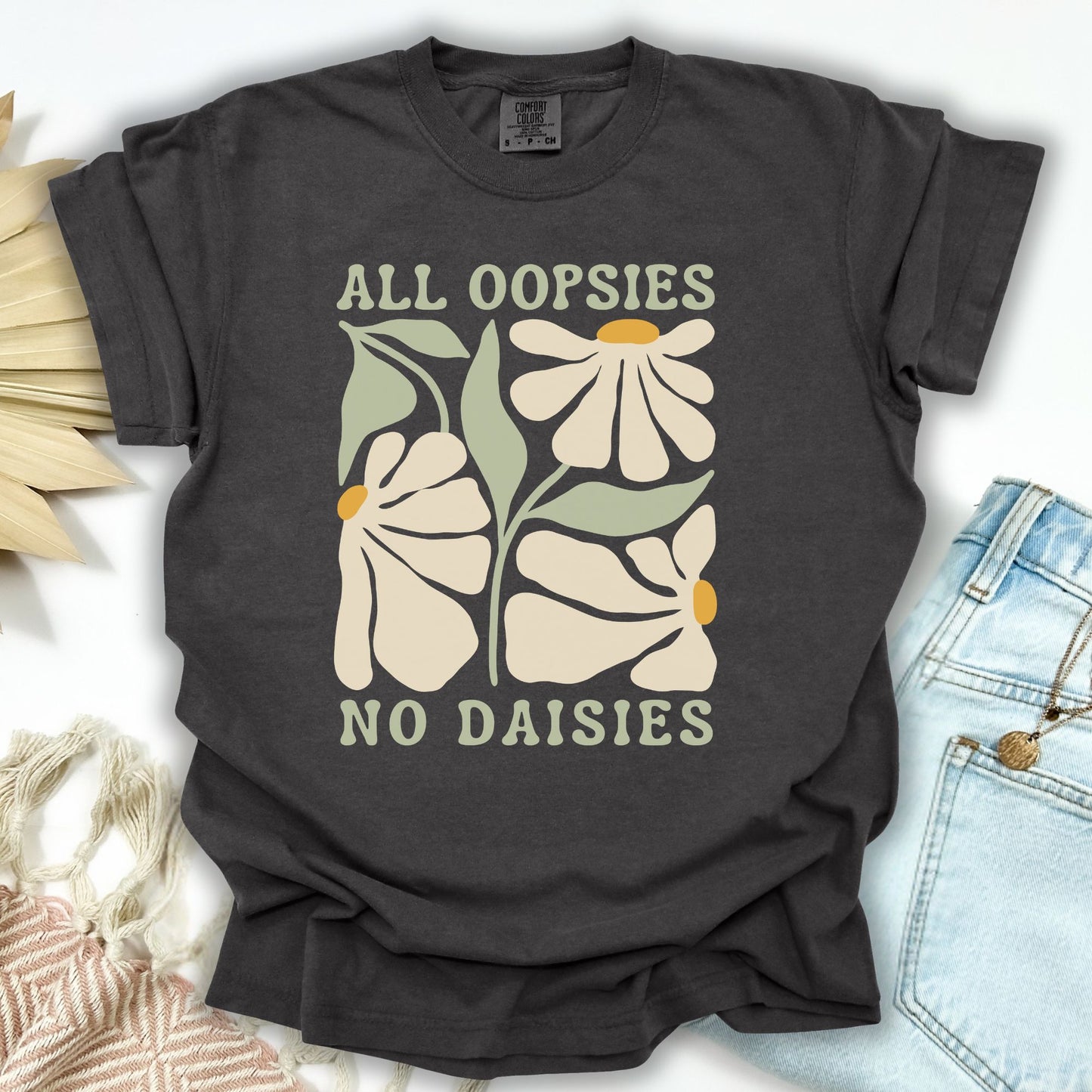 Pepper S garment-dyed t-shirt with "All Oopsies No Daisies" retro floral graphic.