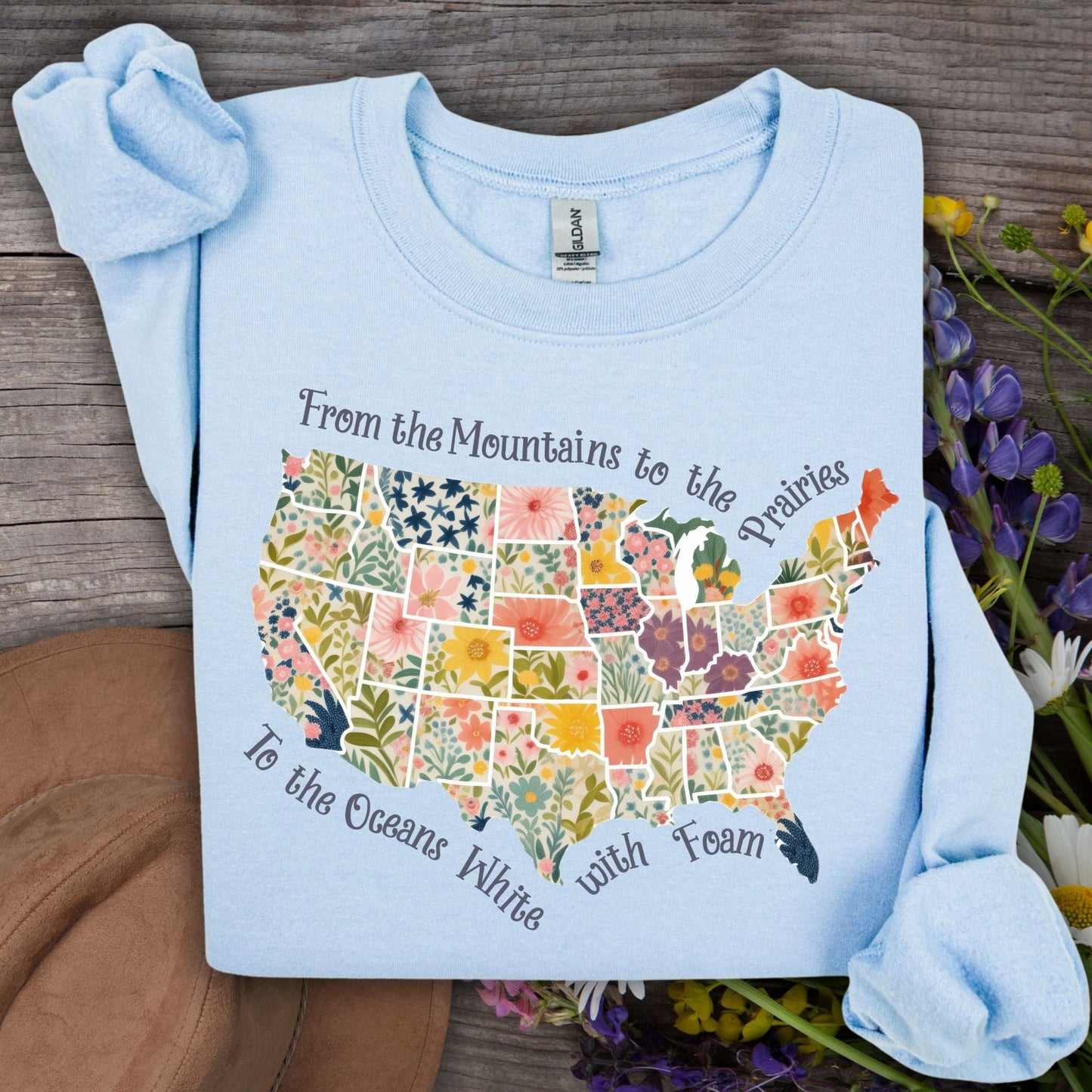 Light blue crewneck sweatshirt with a watercolor floral map of the USA and "America the Beautiful" script.