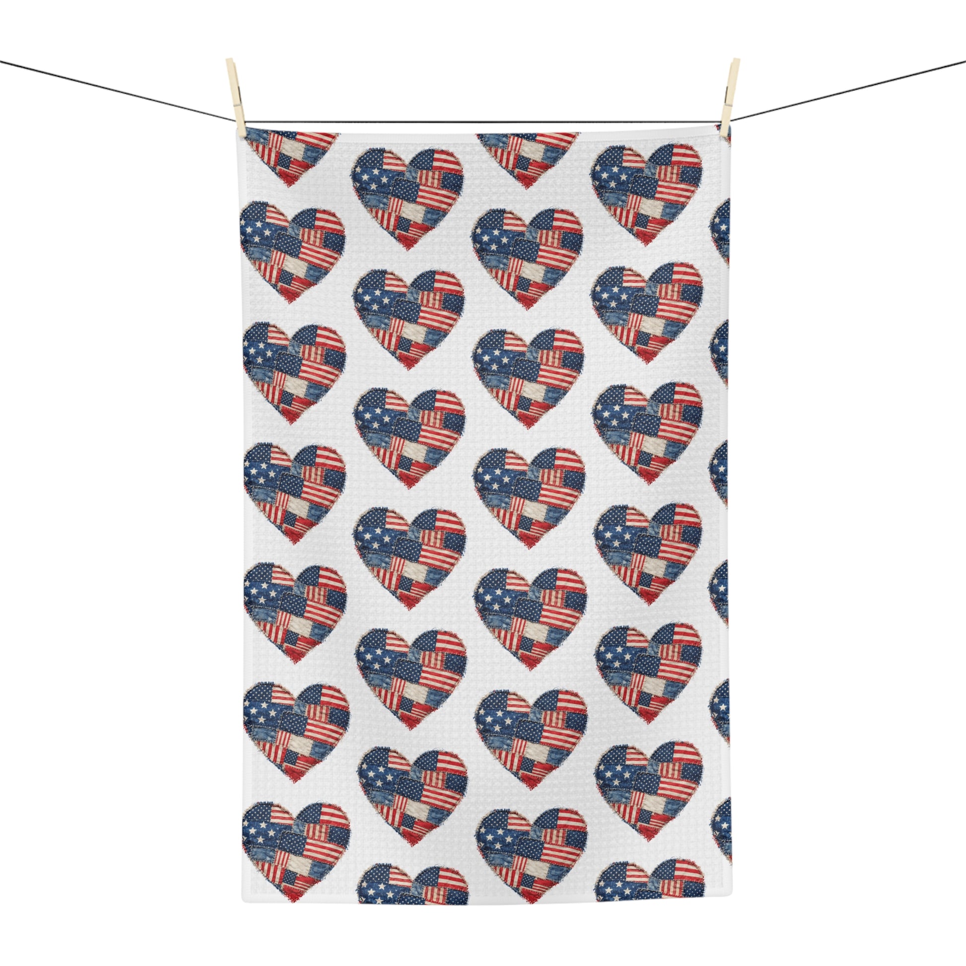 Microfiber tea towel with repeating American flag patchwork heart pattern, hanging from a clothesline.