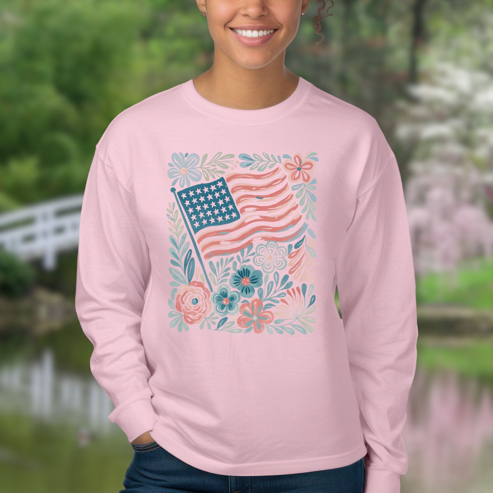 Pink long sleeve tee with a muted red and blue American flag surrounded by hand-drawn flowers and leafy flourishes.